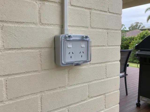 Weatherproof double power point on a painted brick exterior wall near a patio in Buff Point